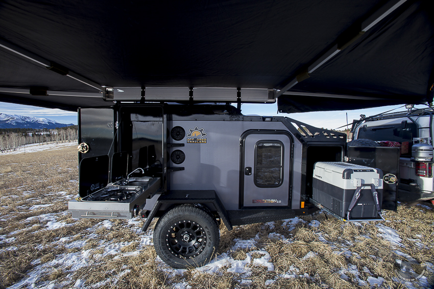Off Grid Trailers Expedition 2.0 fully deployed with fold down kitchen and slide out fridge opened.  23Zero 270° awning provides wrap around shade.